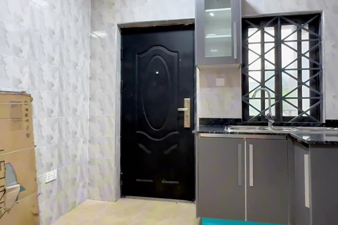 Fitted kitchen with grey cabinets and a black worktop